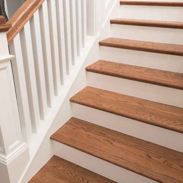 Trappe med brune trætrin og hvid ræling