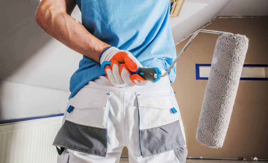 maler der står med ryggen til og holder en malerrulle