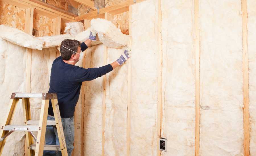 Vægisolering - Håndværker i gang med at isolere en væg
