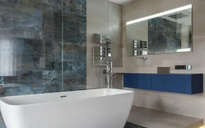 Moderne badeværelse med hvidt badekar i forgrunden og en væg bagved med farvede fliser