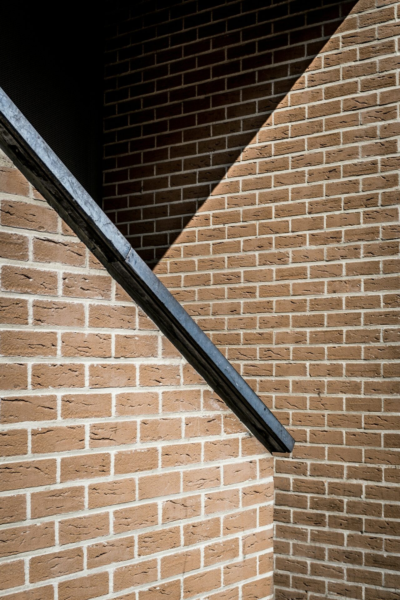 trappe af mursten med sort gelænder i træ