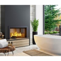 Hvidt badekar ovenpå et trægulv foran en sort tændt kamin med et stort gulvvindue i baggrunden