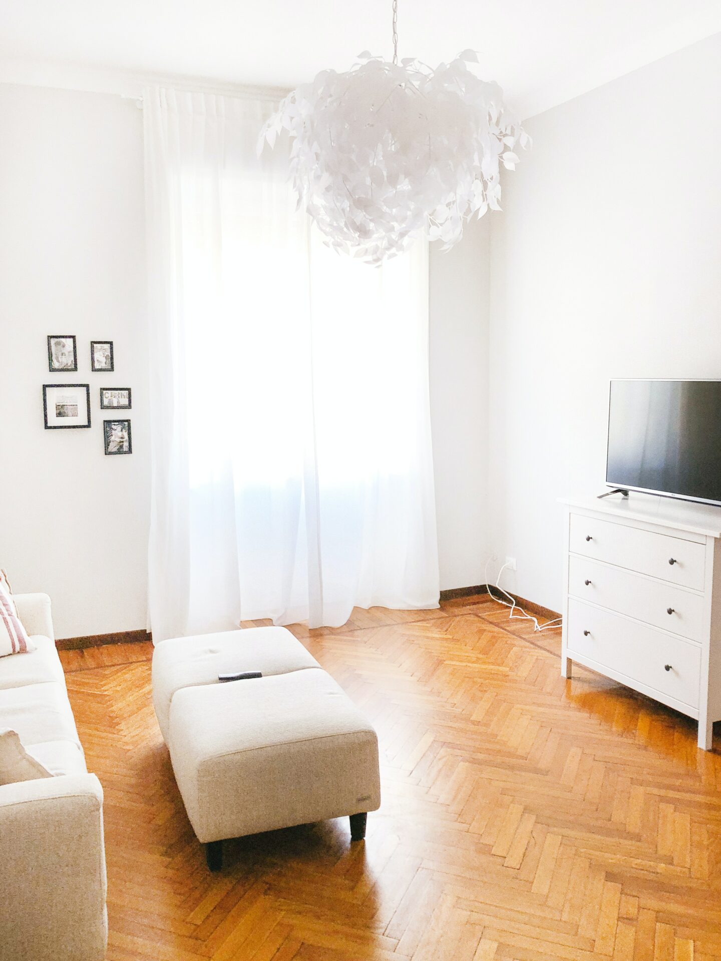 Hvidt rum og et lyst trægulv med hvide møbler 